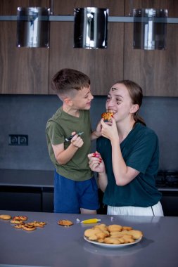 Anne ve oğlu taze pişmiş zencefilli ekmek yiyorlar..