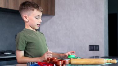 Evdeki mutfakta kurabiye keskisi ve hamur kullanarak kurabiye yapan küçük çocuk..