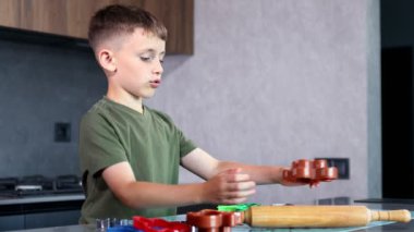 Evdeki mutfakta kurabiye keskisi ve hamur kullanarak kurabiye yapan küçük çocuk..