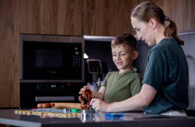 Anne ve oğul mutfakta birlikte yeni yıl kurabiyesi pişiriyorlar. Yeni yıla hazırlık konsepti, Noel tatili..