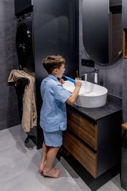 Banyoda dişlerini fırçalayan sevimli küçük çocuk..