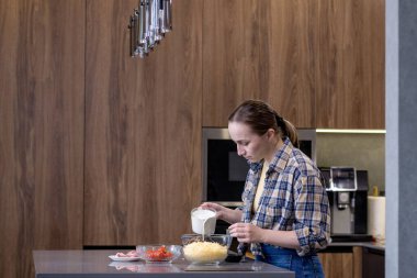 Genç bayan mutfakta kiş hazırlıyor..