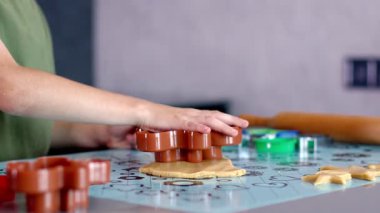 Evdeki mutfakta kurabiye keskisi ve hamur kullanarak kurabiye yapan küçük çocuk..