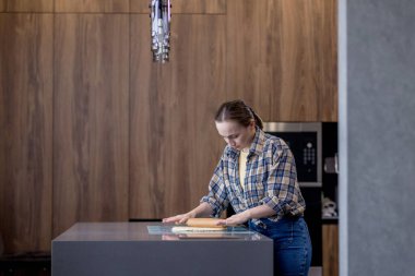 Kadın ustalıkla hamur saçıyor. Mutfakta uzmanlığını gösteriyor..