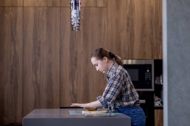 Kadın ustalıkla hamur saçıyor. Mutfakta uzmanlığını gösteriyor..