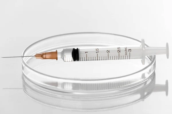 実験室の白い背景にペトリ皿への注入のための液体透明ワクチンで注射器と注射針 生化学 分子生物学 遺伝学と臨床化学の概念 — ストック写真