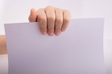Beyaz bir arka planda beyaz bir kağıt tutuyordu.