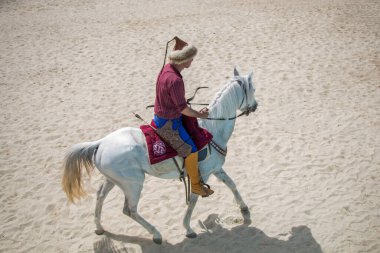 Osmanlı atlısı etnik kıyafetleriyle atına biniyor.