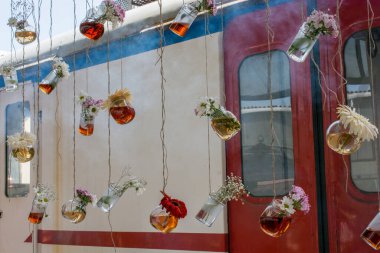 İplere asılı çiçekli bitkisel çay şişeleri