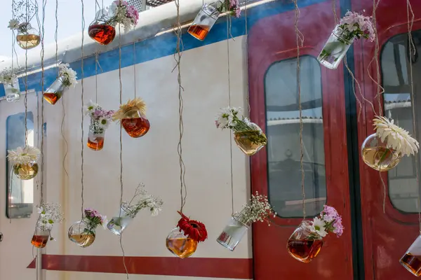 İplere asılı çiçekli bitkisel çay şişeleri