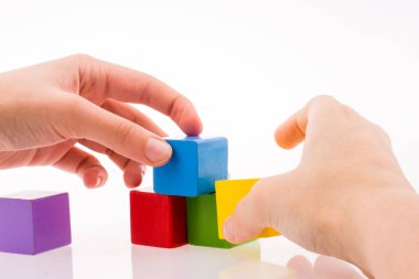 Beyaz arka planda renkli küplerle el oynamak