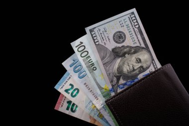 El ele tutuşan Amerikan doları banknotları siyah arka planda izole edilmiş.