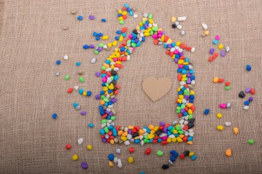 Renkli çakıl taşlarıyla şekillendirilmiş evdeki kalp.