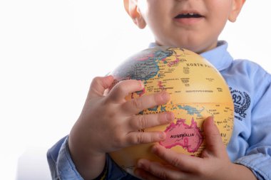 Bebek beyaz arka plan üzerinde elinde bir küre tutan mavi gömlek ile