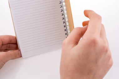 Beyaz bir arkaplanda elinde bir defter var.