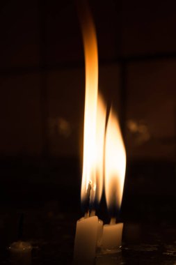 Karanlıkta mum ışığında yanan mumlar.