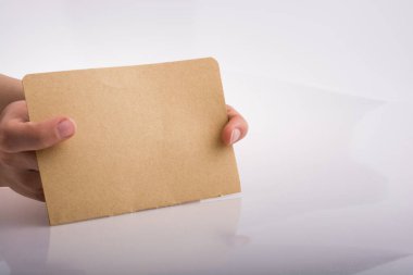 Beyaz arka planda bir sayfa kağıt tutarken