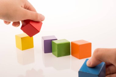 Beyaz arka planda renkli küplerle el oynamak