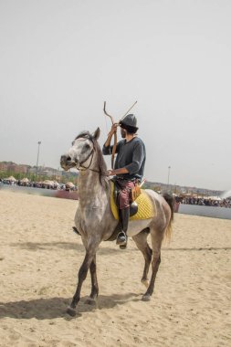 Osmanlı atlısı etnik kıyafetleriyle atına biniyor.
