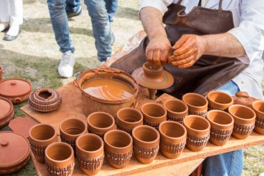 Potter 'ın elleri çömleğin kilini şekillendiriyor.