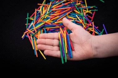 Beyaz arka planda yaratıcılık için renkli tahta çubuklarla oynayan çocuk