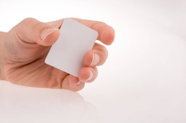 Beyaz arka planda bir kağıt parçasını tutan el.