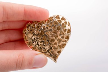 Kalp şeklinde altın renginde metal bir nesne
