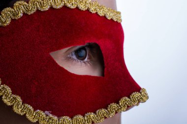 Karnaval maskesi liwhite arka plan üzerinde çocuk bakar