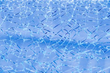 Arka planda çatlaklar olan kırık camlar.