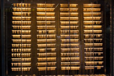 Onlarca altın bilezik ve bileziğin sergilendiği bir dükkan.