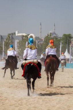 Atlılar at sırtında etnik kıyafetleriyle geziyorlar.