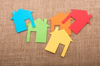 Tuvalin arka planında renkli kağıttan kesilmiş küçük bir ev şekli