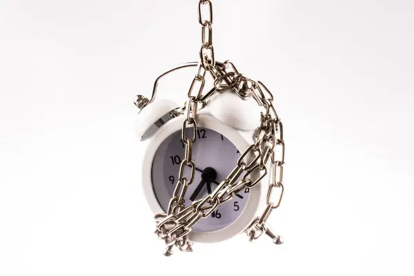 stock image White color alarm clock in chain on a white background