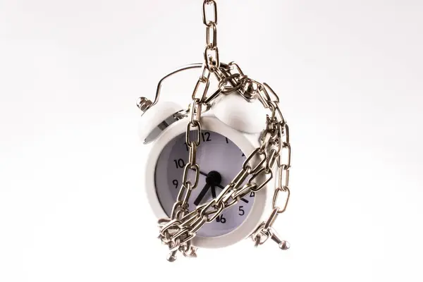 Stock image White color alarm clock in chain on a white background