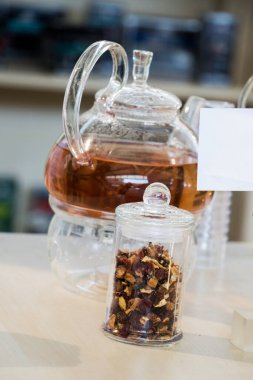 Cam çaydanlıkta demlenmiş bitki çayı ve şişede çay bitkisi.