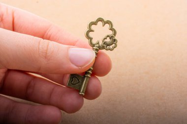 Elinde eski moda dekoratif bir anahtar var.