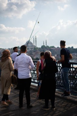 Golden Horn 'daki Galata Köprüsü' nde balık tutan adam.