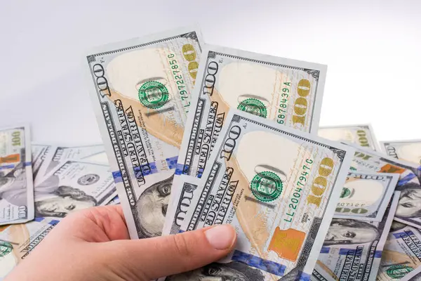 İnsan eli, Amerikan doları banknotunu beyaza izole edilmiş olarak tutuyor.