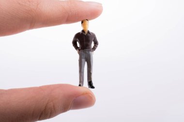 Beyaz arka planda bir insan figürü tutuyor.