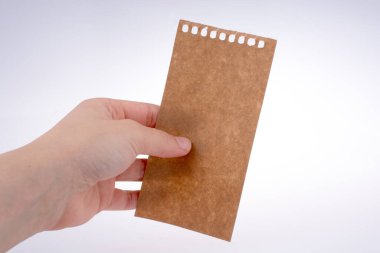 Bir defter--dan yırtık bir kağıt tutan el