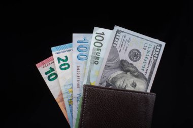 El ele tutuşan Amerikan doları banknotları siyah arka planda izole edilmiş.