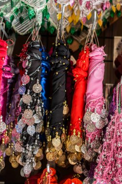 Eşarp kenarlarında bir sürü sahte altın para var.