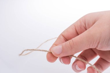 Keten iplik beyaz bir arka plan üzerinde tutan el