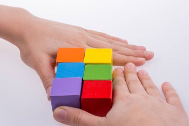 Beyaz arka planda renkli küplerle el oynamak