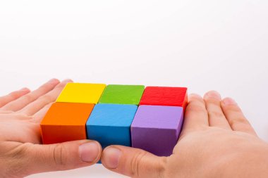 Beyaz arka planda renkli küplerle el oynamak