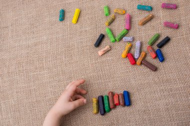 Yeni yürümeye başlayanlar boya kalemlerini tuval üzerine diziyorlar.