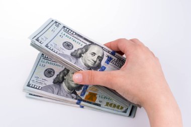 İnsan eli, Amerikan doları banknotunu beyaza izole edilmiş olarak tutuyor.