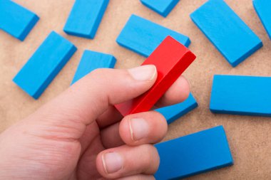 Çeşitli renklerin ahşap bloklarından birini tutarken