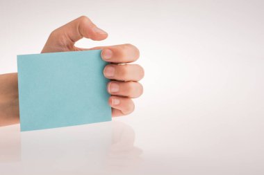 Beyaz bir arka plan üzerine açık mavi renk dikdörtgen kağıt tutan el