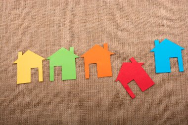 Tuvalin arka planında renkli kağıttan kesilmiş küçük bir ev şekli